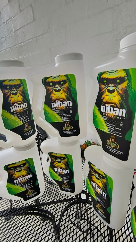 A row of Niban granular bait shakers wearing the company label with the Sasquatch artwork, the Bellingham address and the phone number
