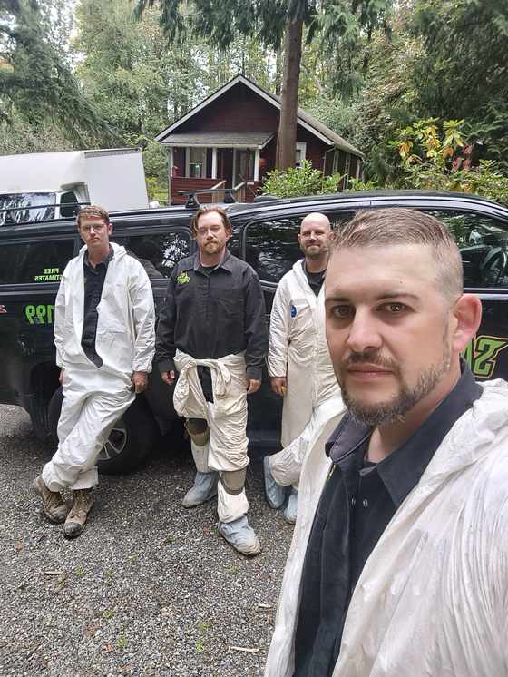 Technicians in protective suits at a crawlspace job site