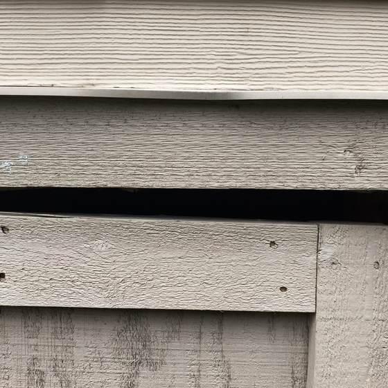 A dark gap between boards of a home's lap siding