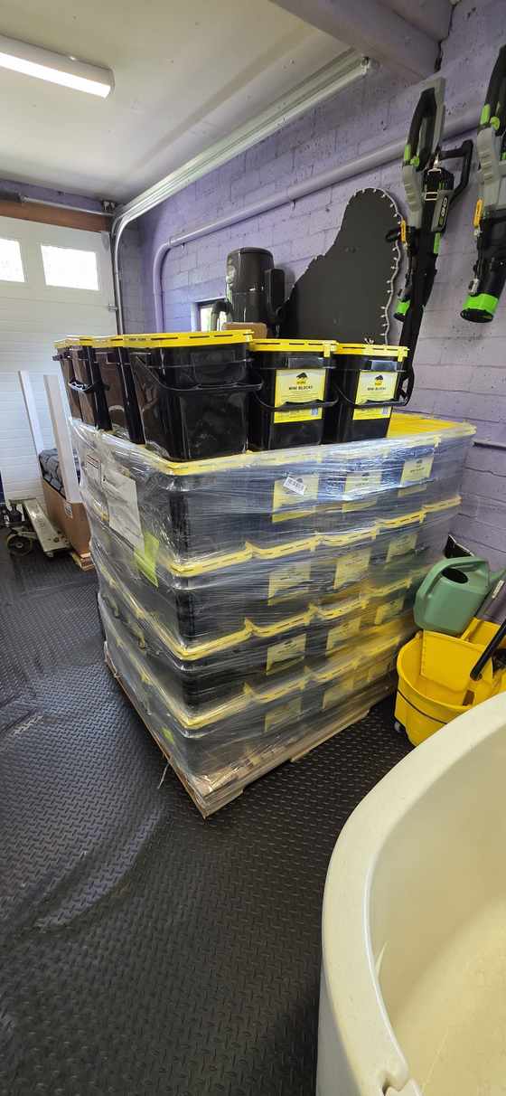 Shrink-wrapped pallet of pest control bait and supplies in a warehouse