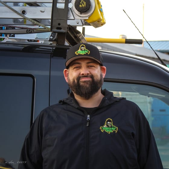 Tyson Elling in a branded cap and jacket in front of the ladder-racked van